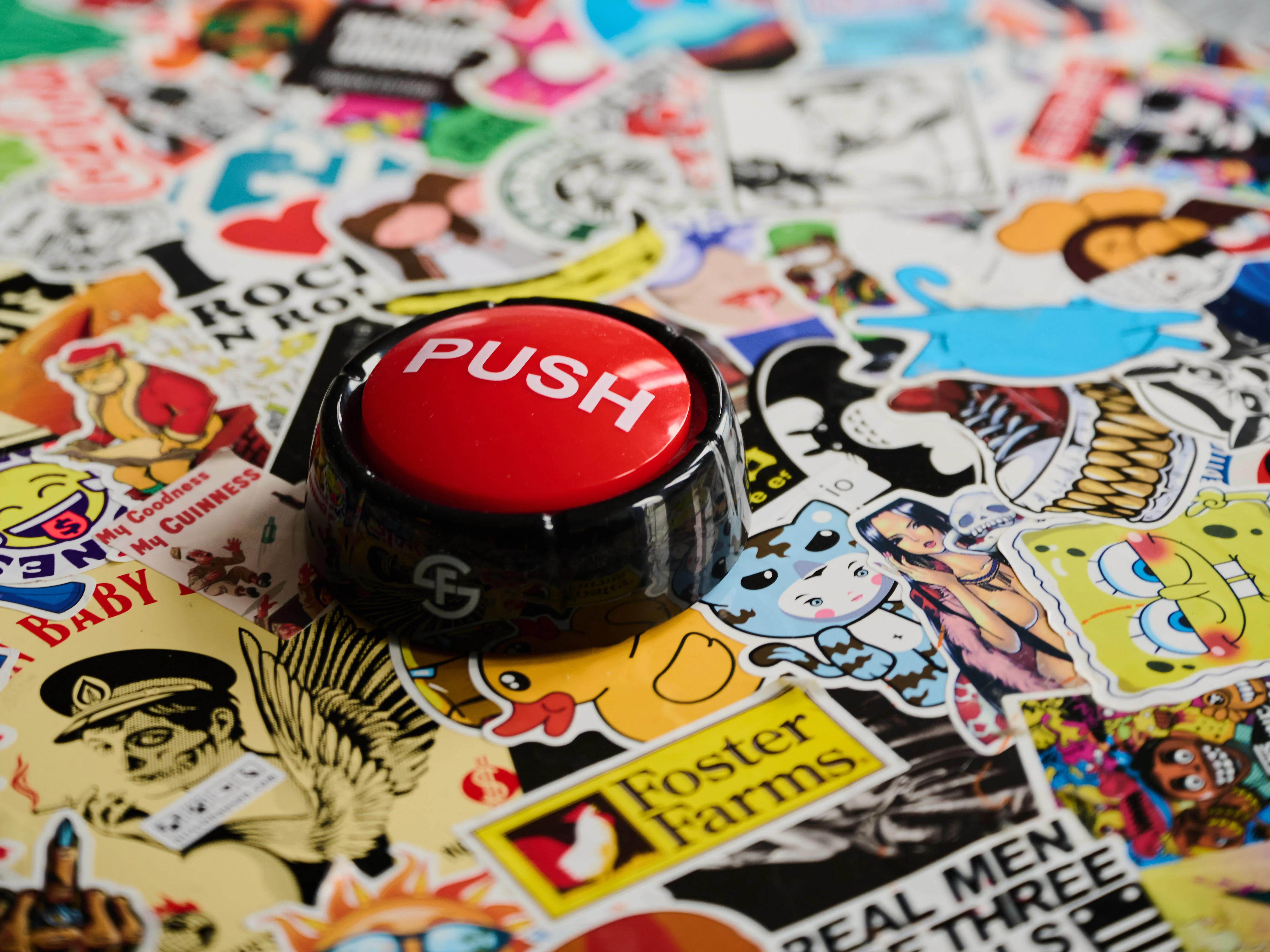 Roter Druckknopf auf einem Stapel Aufkleber