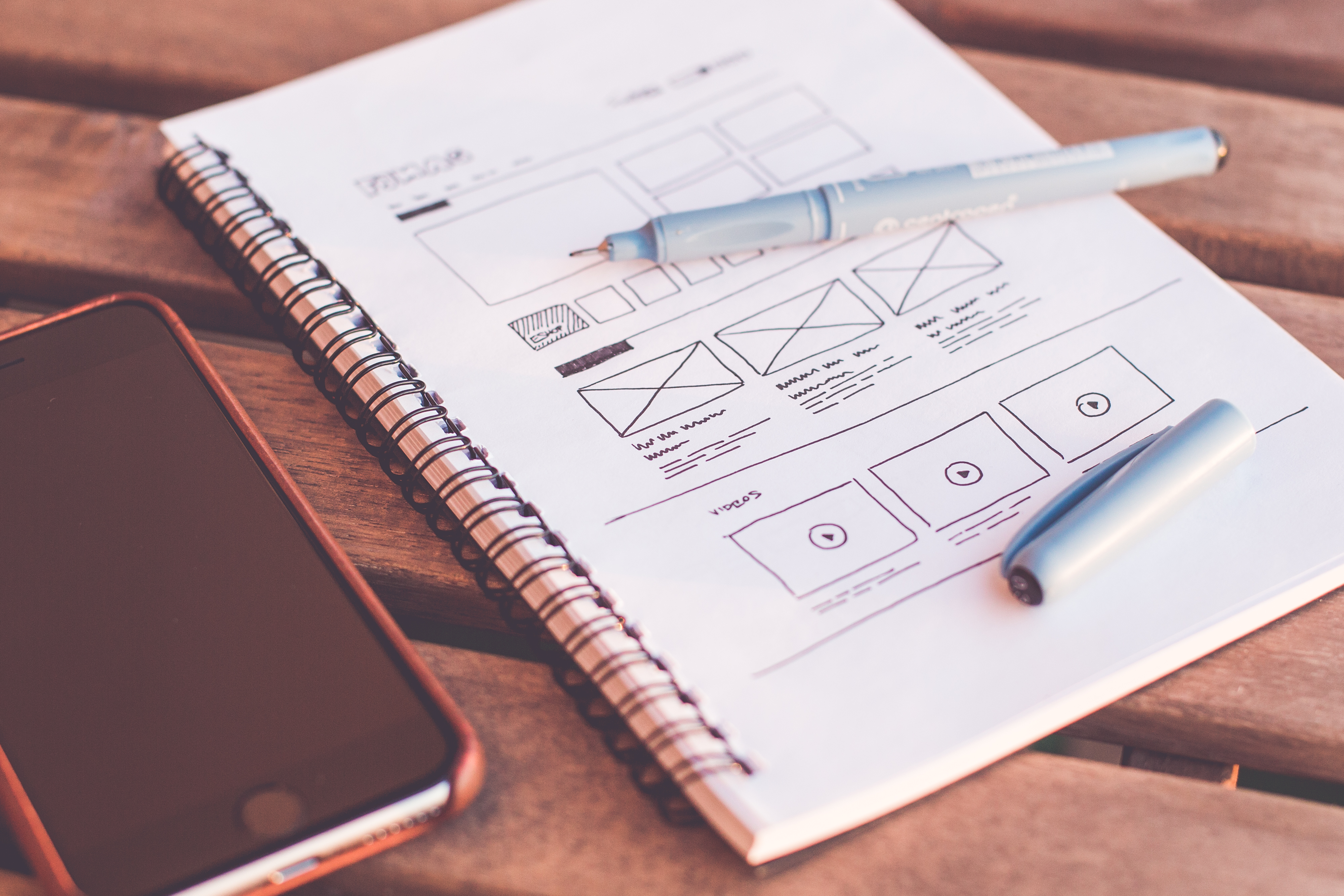 notebook beside the iphone on table LEAN UX FÜR ANFÄNGER - UND WIE MAN ES EINSETZT